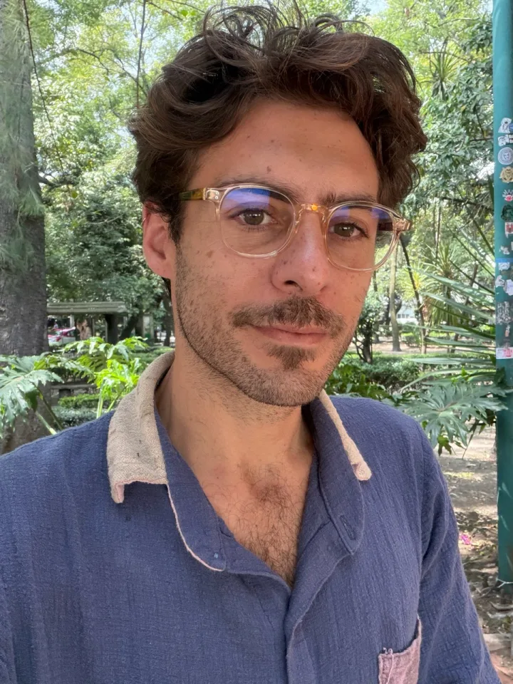 Jordi Amat outdoors, wearing glasses and a blue shirt.